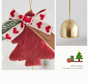 Detailed close-up of dark red plush Christmas tree ornament with golden bell and bow