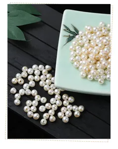Macro detail of 4-5mm white freshwater pearls for jewelry making on a green ceramic dish