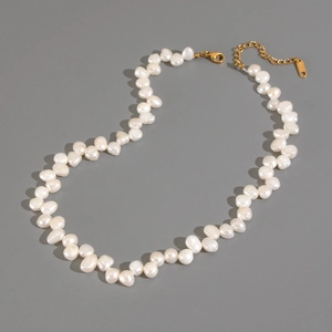 Flat lay of baroque pearl necklace with golden lobster clasp and extension chain
