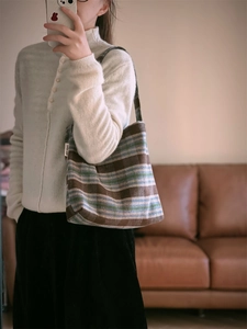 Gros plan d'un sac bandoulière rétro en laine montrant la texture et l'étiquette tissée