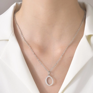 Detailed view of a silver titanium steel necklace featuring a minimalist letter O pendant