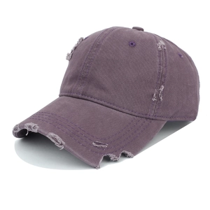 Close-up of distressed vintage purple baseball cap with handmade ripped hole details
