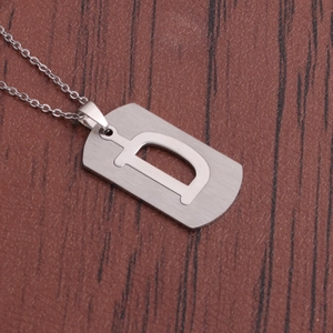 Gros plan sur un collier en acier argenté avec pendentif rectangulaire évidé lettre D