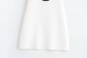 Gros plan détaillé de l'ourlet de la mini robe blanche en maille à texture fine