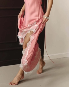 Détail d'une nuisette en soie rose montrant un éclat luxueux et une fine dentelle blanche