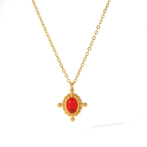 Detail of gold titanium necklace with oval red gemstone and star-shaped metal casing