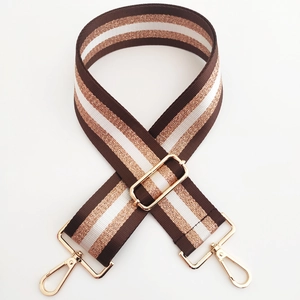 Detail of adjustable 5cm woven bag strap with gold stripes and luxury metal lobster clasps