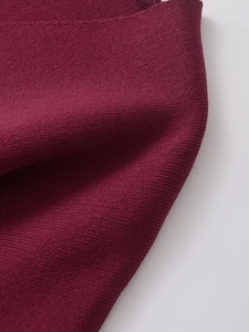 Close-up of deep wine red V-neck knit jacket texture showing fine stitch craftsmanship