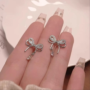 Detailed close-up of S925 silver butterfly stud earrings with white cubic zirconia crystals