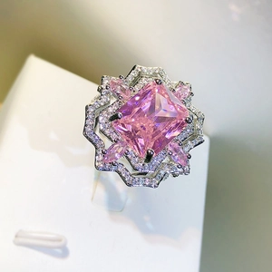 Macro shot of pink ice flower cut gemstone ring with silver setting and halo diamonds