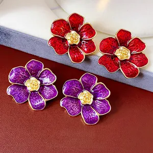 Pendientes de flores vintage con pétalos de esmalte rojo y rosa dorada sobre cuero