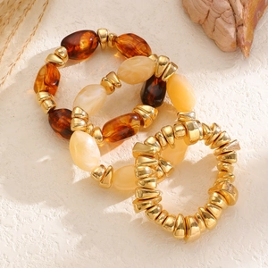 Detailed macro of vintage style amber resin and gold beaded elastic bracelet set