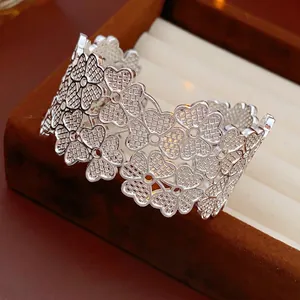 Wide silver hollow clover bangle with mesh petal texture on velvet jewelry box