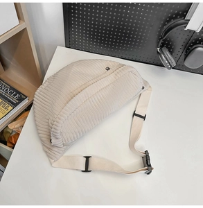 Detailed view of the off-white corduroy texture and adjustable strap on the crossbody bag