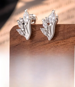 Macro detail of silver leaf cartilage studs featuring brilliant marquise zircon stones