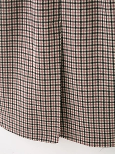 Detailed close-up of high-quality black and purple plaid fabric texture on long coat
