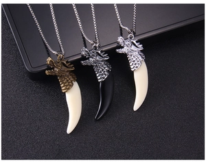 Detailed view of wolf tooth pendant necklaces in bronze and silver finishes for men
