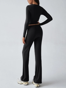 Back view of black Y2K slim fit long sleeve crop top and flared pants set for women