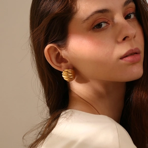 Détail de boucles d'oreilles nœud ovale plaqué or 18 carats avec texture en spirale moderne