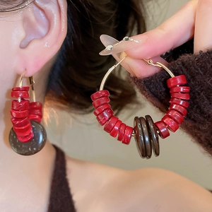 Détail de boucles d'oreilles créoles vintage en bois de coco portées par un mannequin