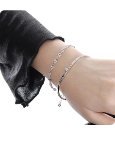 Detail shot of a silver open cuff bracelet with irregular texture and a tiny diamond accent