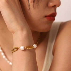 Detail of 18k gold plated geometric chain bracelet with pearls on a female wrist
