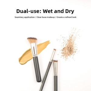 Detailed view of three professional makeup brushes with foundation and powder textures