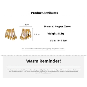 Detailed specs of C-shaped gold earrings with zircons and shell inlays on silver pins