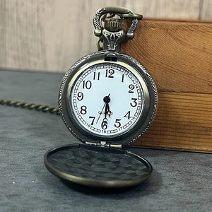 Macro shot of bronze vintage pocket watch with ornate carvings and white quartz dial