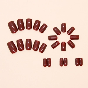 Glossy cherry red cat eye press-on nails in various sizes on a neutral background