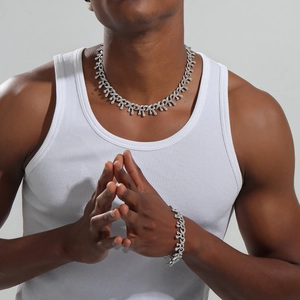 Détail d'un ensemble collier et bracelet hip hop argenté avec strass brillants sur modèle homme