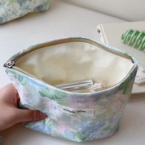 Detailed interior of a floral makeup bag featuring a zipper closure and beige lining