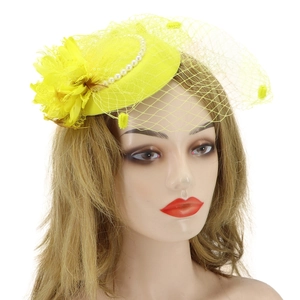 Detail of yellow fascinator featuring mesh veil with elegant fabric flower and pearl accents
