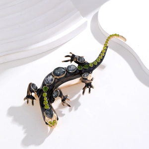 Vue détaillée de la broche lézard avec strass verts et finition en émail noir
