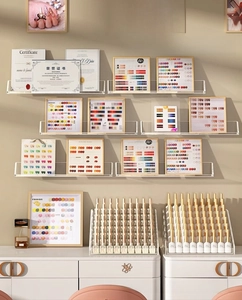 Close-up of clear acrylic wall U-shaped shelf displaying nail polish and certificates