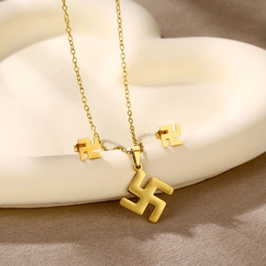 Detailed view of golden heart and geometric angel pendant set on white display tray