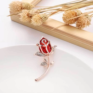 Exquisite rose-shaped brooch in rose gold with a large red crystal and micro-pave accents
