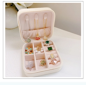 Close-up of cream square jewelry box interior with hooks, ring slots and necklace pockets