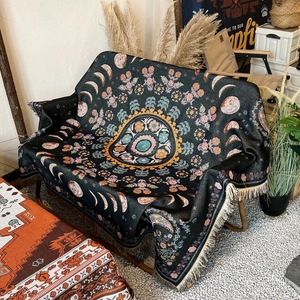 Detail of bohemian mandala throw blanket featuring phases of the moon and fringe
