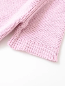 Detail of pink knitted sleeve with ribbed texture and high-quality stitching detail