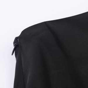 Close-up of invisible zipper detail on black asymmetric lace top showing fabric texture