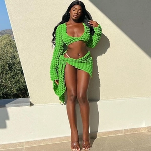 Detailed view of textured lime green two-piece set featuring long-sleeved crop top and skirt