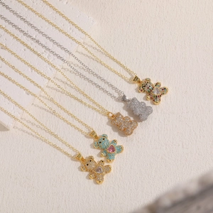Detailed macro view of colorful zircon bear pendants with heart stones on gold chains