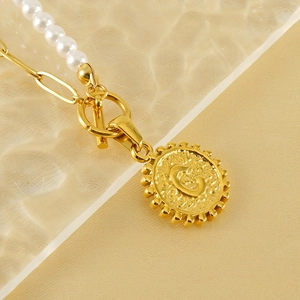 Minimalist pearl and gold paperclip necklace with a hammered initial C coin pendant