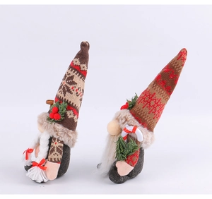 Close-up of knit Christmas gnomes with snowflake patterns, faux fur, and candy cane detail