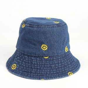 Detail of yellow embroidery smiley face pattern on navy blue denim bucket hat material
