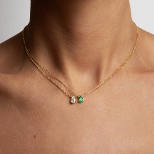 Double-layered gold necklace featuring pear-cut white and green zircon stone pendants