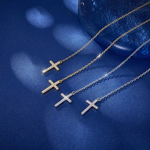 Detail view of cross necklaces in gold and silver finish with sparkling zircons on dark background
