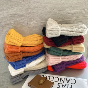 Detailed pile of thick cable knit beanies in various colors for autumn and winter warmth