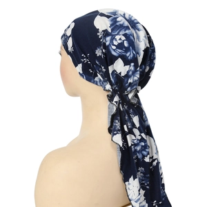 Detail view of the floral print headscarf with long tails and dark blue fabric texture